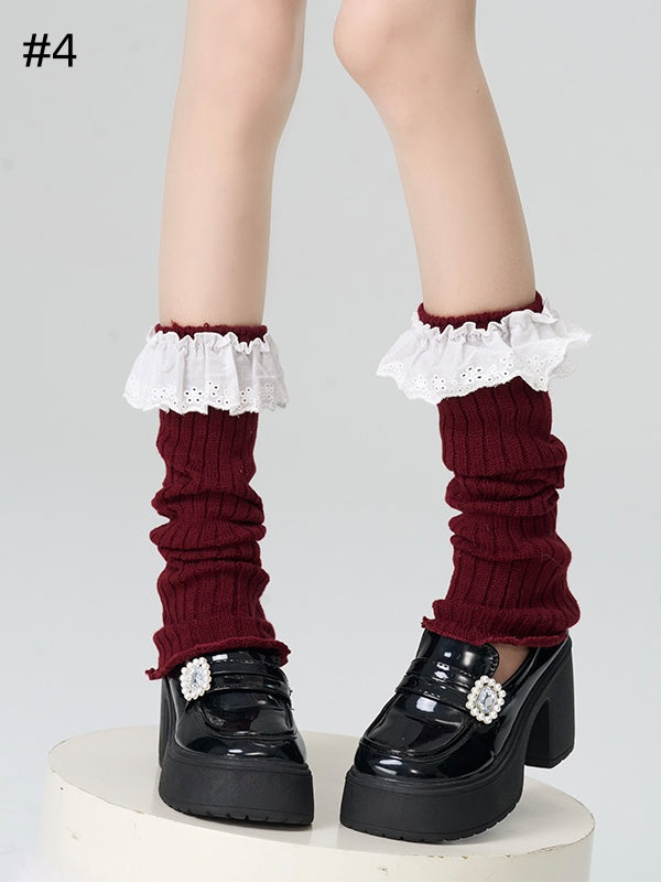 Gestrickte Beinwärmer mit rotem Spitzenbesatz