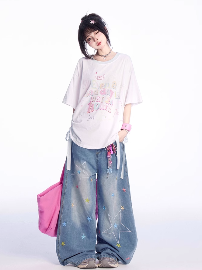 ゆったりとしたTシャツ。裾のディテール。ホワイトのラウンドネック。レタープリント。蝶結び。