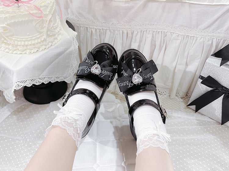 Polierte schwarze Mary Janes mit herzförmiger Strassschleife am oberen Blockabsatz