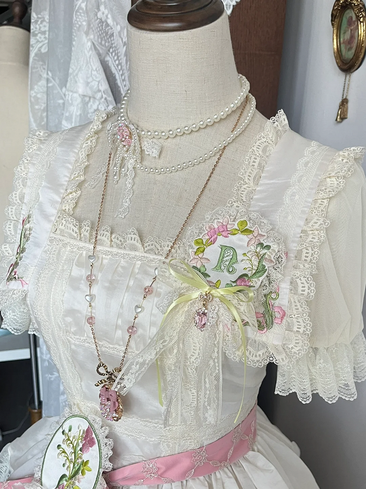 Blumenbrosche mit Spitzenbesatz und Stickerei