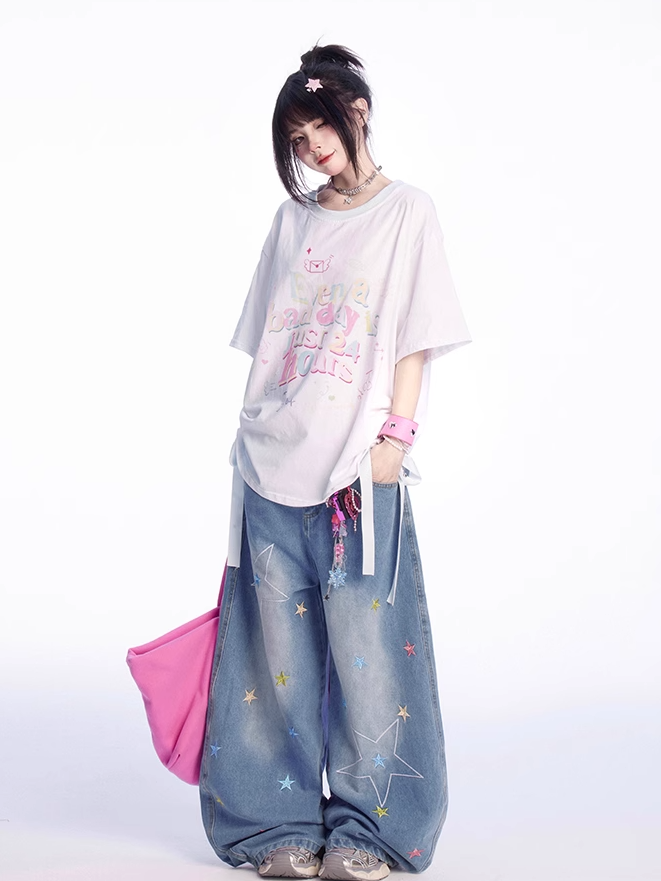 ゆったりとしたTシャツ。裾のディテール。ホワイトのラウンドネック。レタープリント。蝶結び。