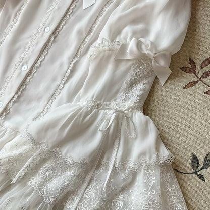 Weiße Bluse mit Glockenärmeln und Schleifenverzierung