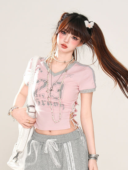 サイドにレースアッププリント、ピンクのVネックにナンバーディテールが入ったグラマラスなクロップドTシャツ