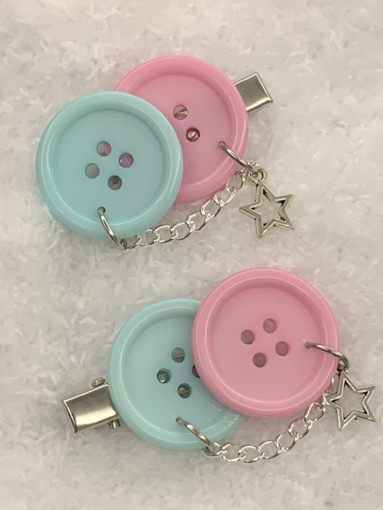 Blaue und rosa Haarspangen mit Knöpfen
