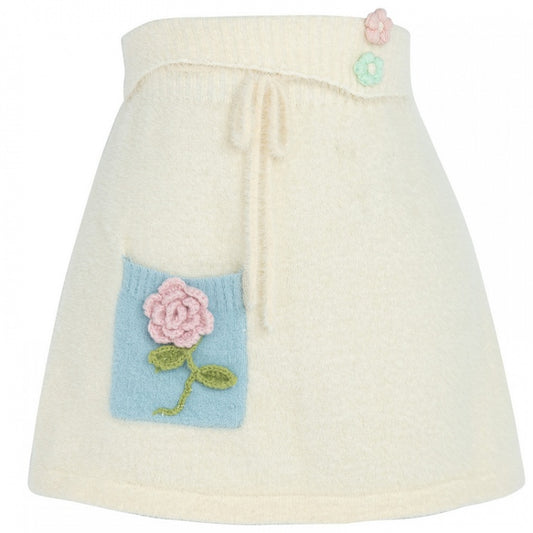 フロントにセルフタイストラップが付いたベージュの花柄ニットスカート