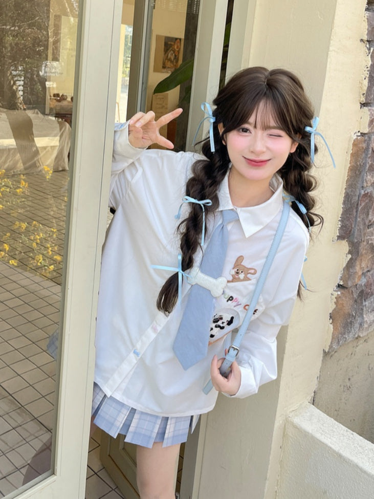 キティの青いネクタイとボーンパピーのアップリケがあしらわれた白いゆったりシャツ