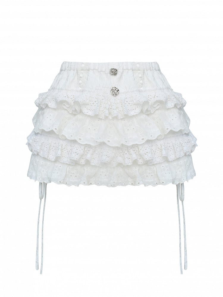 Jupe-short argentée ornée de dentelle blanche en forme de rose et de boutons étagés.