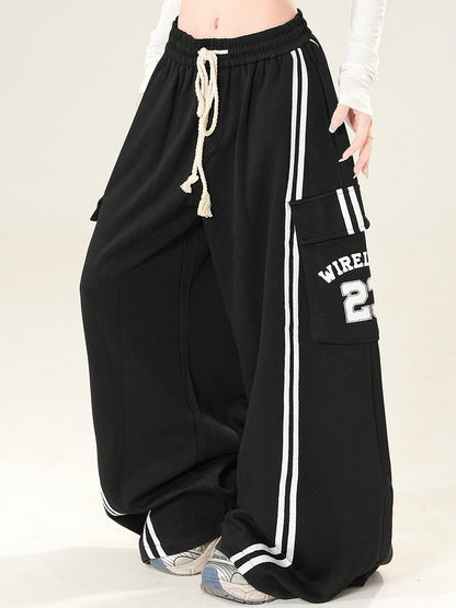 数字をあしらったブラックワイドレッグパンツ、ポケット付きレターカーゴカットプリント、ほろ苦い