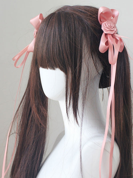 蝶結びのディテール、ロゼット装飾のピンクのヘアクリップ