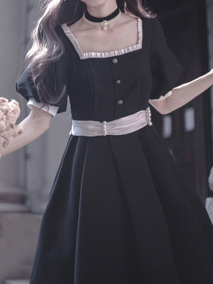 Schwarzes Puffkleid mit elegantem Ausschnitt und Ärmeln