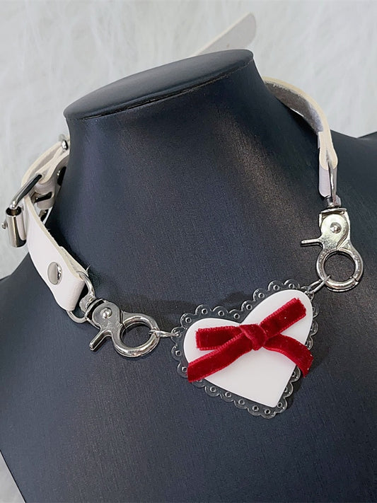 Halsband mit weißem herzförmigem Anhänger und roter Schleife