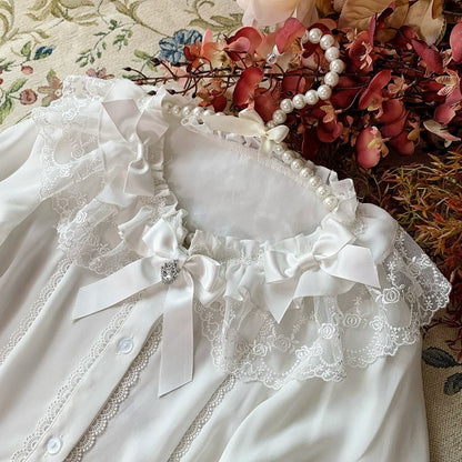 Weiße Bluse mit Glockenärmeln und Schleifenverzierung