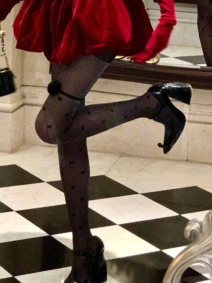 ローズのアクセントが付いた、黒の水玉模様のキラキラ輝くタイツ