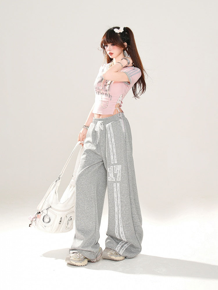 サイドにレースアッププリント、ピンクのVネックにナンバーディテールが入ったグラマラスなクロップドTシャツ