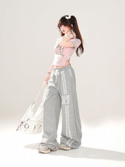 サイドにレースアッププリント、ピンクのVネックにナンバーディテールが入ったグラマラスなクロップドTシャツ