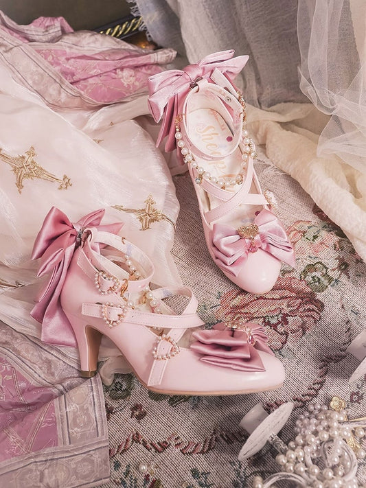 ピンクのハートのリボンにビーズをあしらったライトチャームトップ。クロス飾り付き。