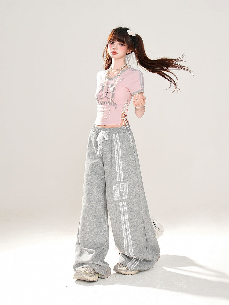 サイドにレースアッププリント、ピンクのVネックにナンバーディテールが入ったグラマラスなクロップドTシャツ