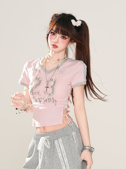 サイドにレースアッププリント、ピンクのVネックにナンバーディテールが入ったグラマラスなクロップドTシャツ