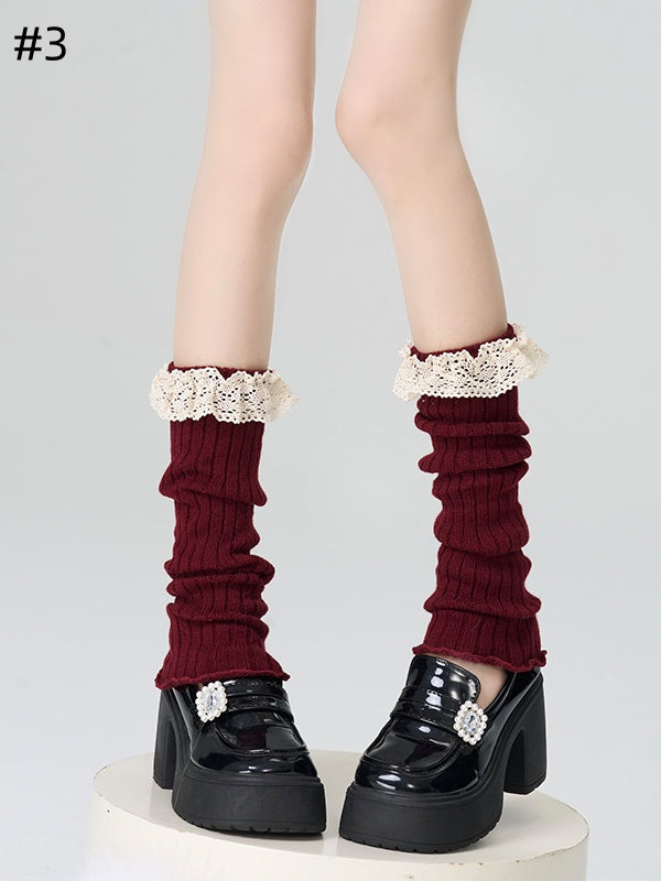 Gestrickte Beinwärmer mit rotem Spitzenbesatz