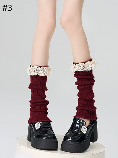 Gestrickte Beinwärmer mit rotem Spitzenbesatz