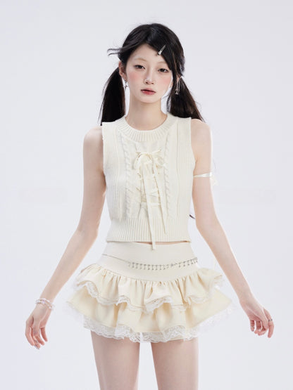 Weiße Spitze, Kreuzdesign, schwarzer, gebogener Saum, glamouröser Mini-Besatz, trägerloser Stufenrock, Spitzenoberteil/Apricot