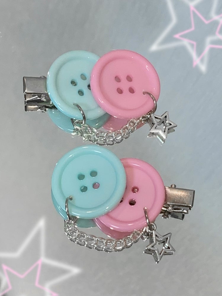 Blaue und rosa Haarspangen mit Knöpfen