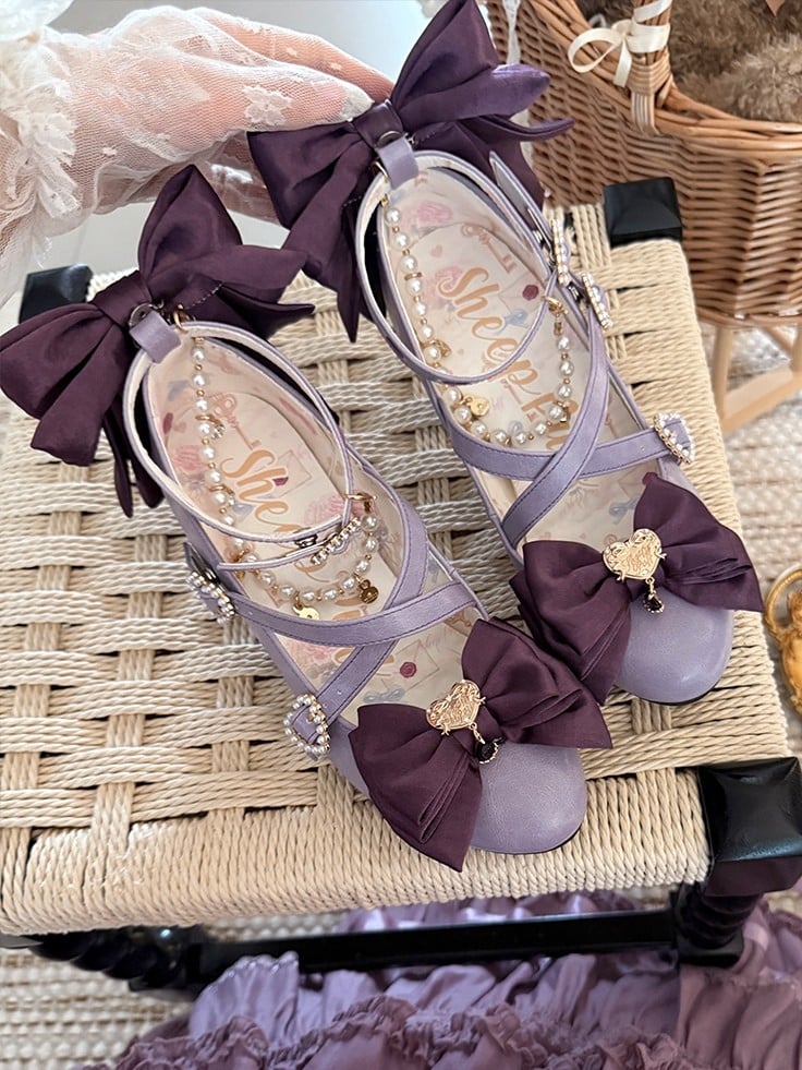 ビーズのハートのクロスデザインのチャームリボン。上部は紫色で装飾されています。