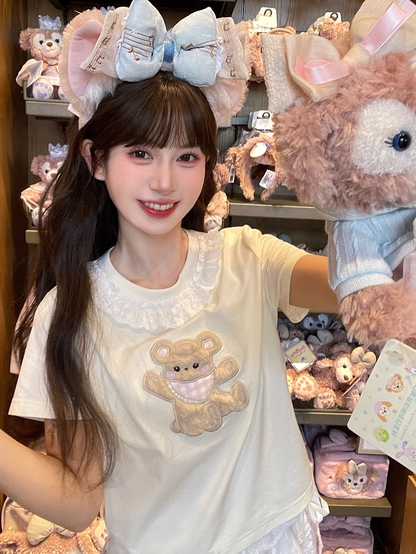 Aprikosenfarbenes T-Shirt mit Spitzenbesatz und Plüschbär-Applikation am Ausschnitt