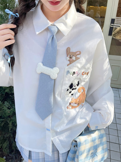 キティの青いネクタイとボーンパピーのアップリケがあしらわれた白いゆったりシャツ