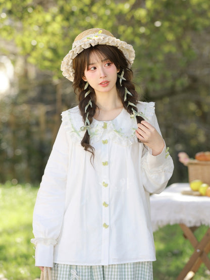 ホワイトレーストリム、丸みのあるフラットカラー、グリーンのリボンボタンブラウス