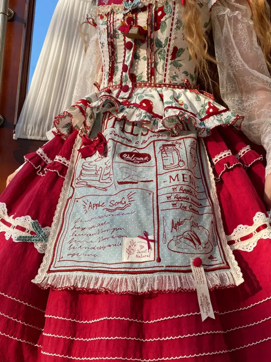 Grüne und rote Schürze mit Stickereidetail