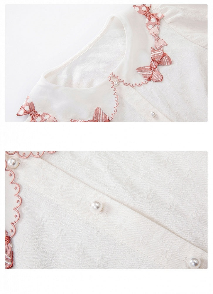 ピンクの蝶結びトリムカラーの白い半袖ブラウス