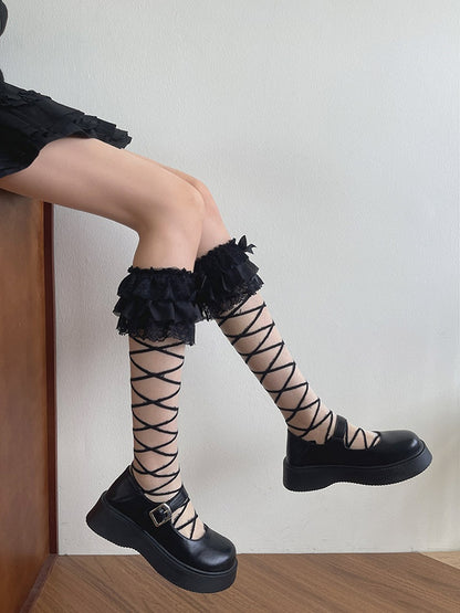 Weiß/Schwarze Strümpfe mit Bändern und Schleife unter dem Knie, überkreuzt