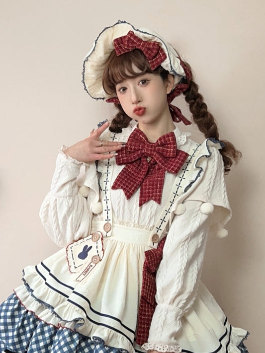 赤い蝶結びのクリーム色のボンネット