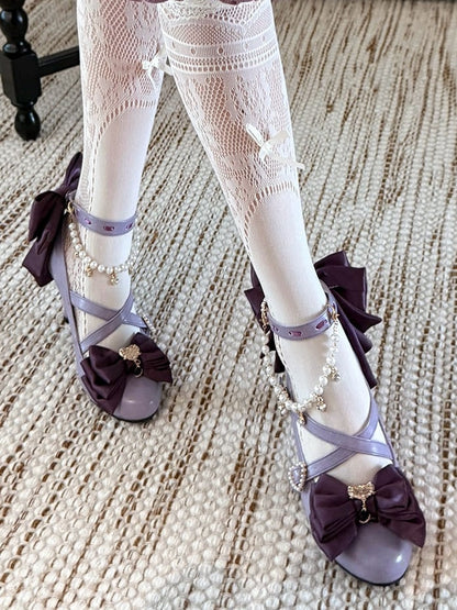 ビーズのハートのクロスデザインのチャームリボン。上部は紫色で装飾されています。