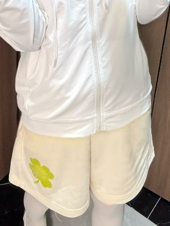 Beigefarbene, lockere Shorts mit Glücksklee-Print