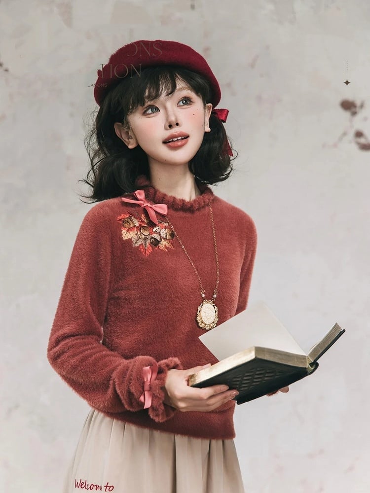 赤い秋のトップスに葉の刺繍とメープル、蝶結びのレンガ色の袖口、ニットのネックライン