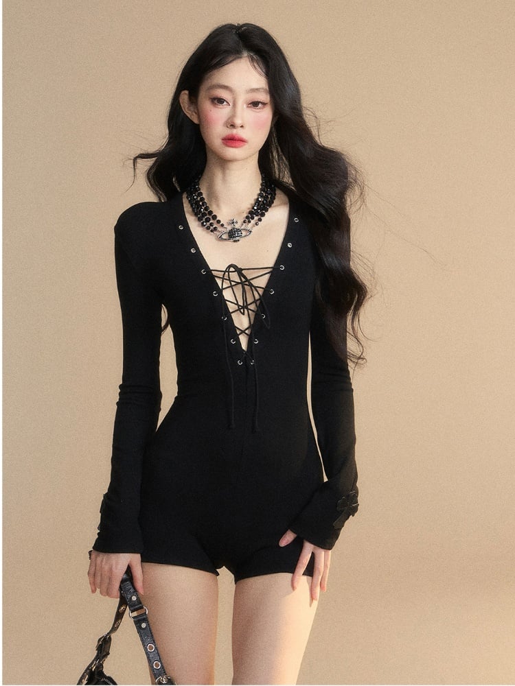 フロントディテールのレースアップジャンプスーツ。ブラックのプランジネックライン。スリムフィット。