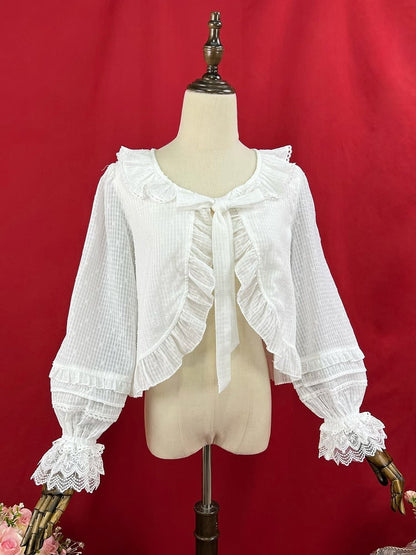 Weißes Oberteil mit Volantbesatz und Knopfleiste, selbstbindendem Ausschnitt und langen Ärmeln