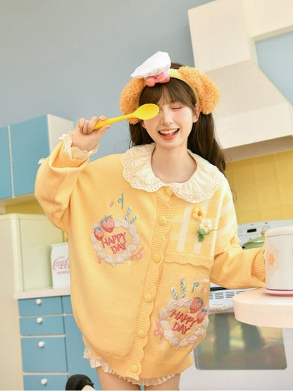 かわいい黄色のニットカーディガン 花柄のアクセント クリーミーな夢のストロベリーケーキの刺繍