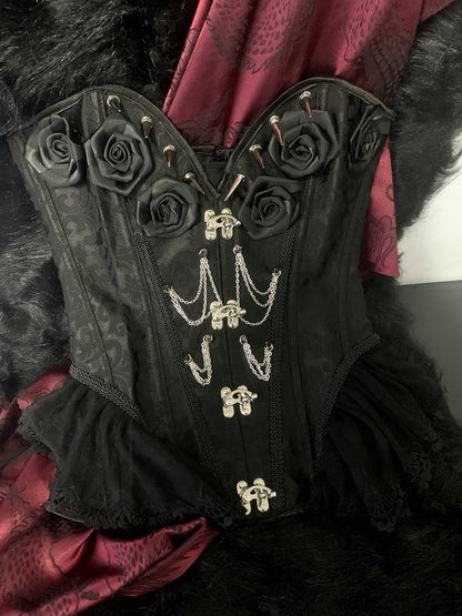 Gothic Korsett mit schwarzen Rosetten und Nieten, verziert mit Kette und Stäbchen