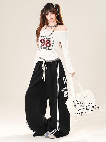 数字をあしらったブラックワイドレッグパンツ、ポケット付きレターカーゴカットプリント、ほろ苦い