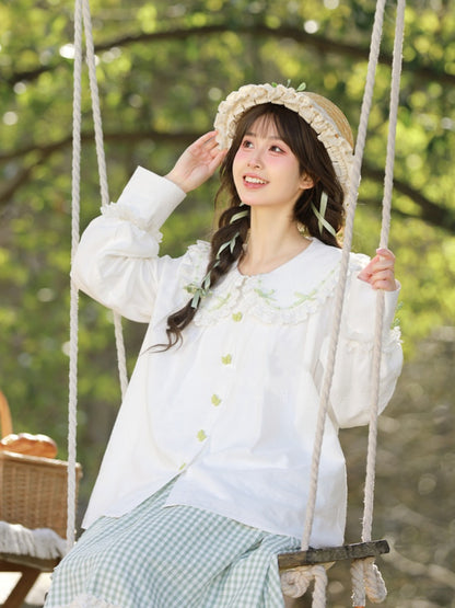 ホワイトレーストリム、丸みのあるフラットカラー、グリーンのリボンボタンブラウス