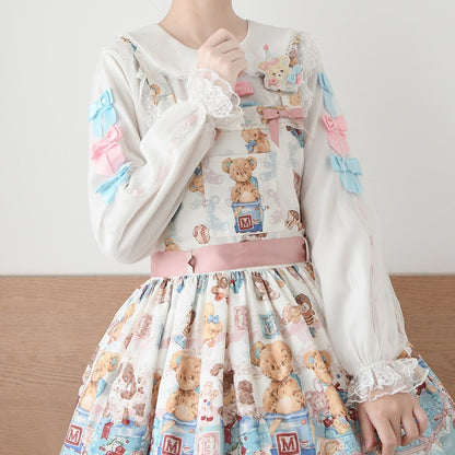 ピンクとブルーのリボンで飾られた白いピーターパンカラーのロングバルーンスリーブブラウス