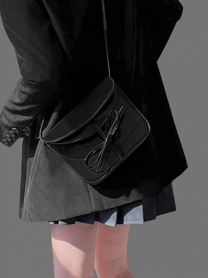 Elegant Black Crossbody Phone Pouch With Glossy Finish And Bow Accent