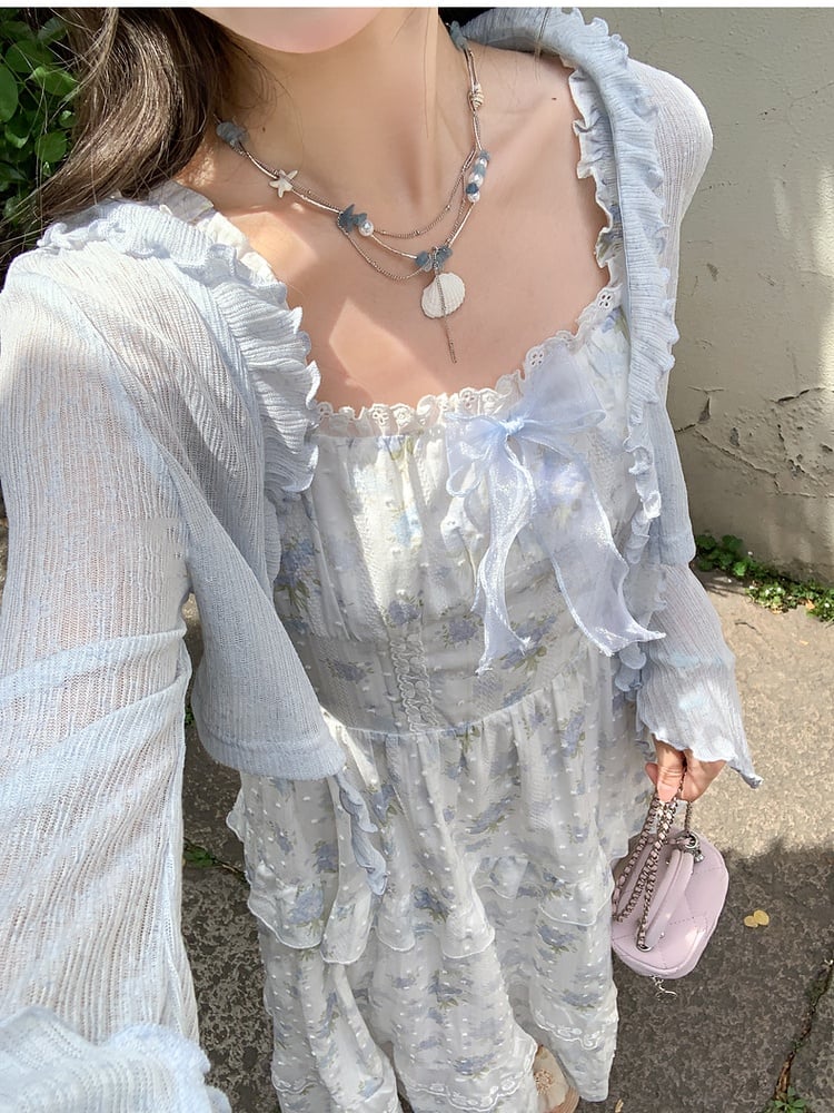 Hellblaues Chiffon-Top mit Rüschendetails und Schleife und Bündchenbesatz und offener Knopfleiste