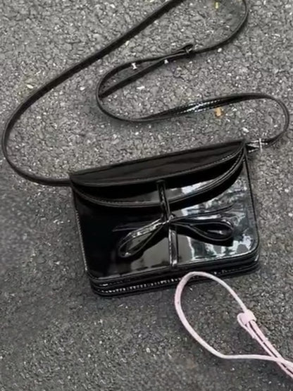 Elegant Black Crossbody Phone Pouch With Glossy Finish And Bow Accent