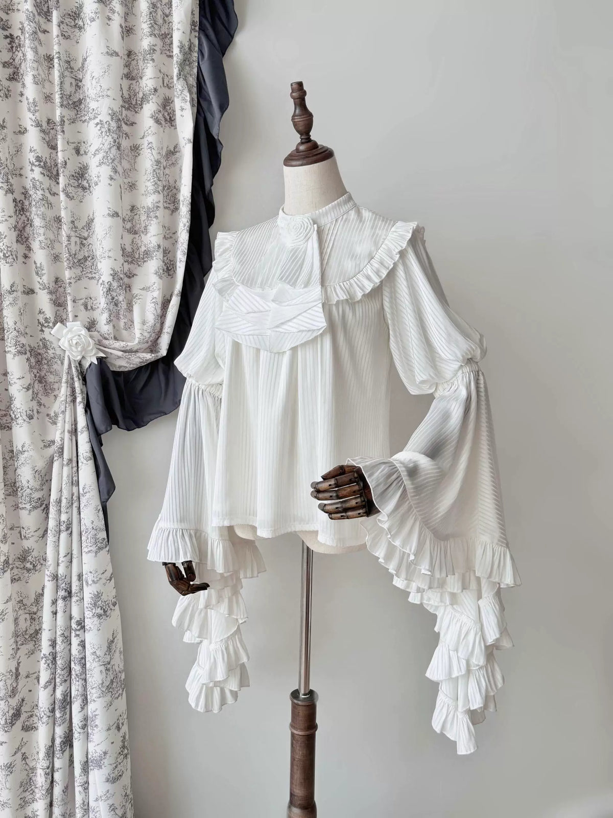 White hime-sleeve blouse with lace bib on mannequin