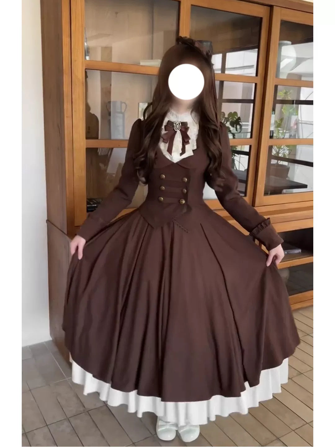 Model holding out the full brown skirt of the three-piece Lolita outfit