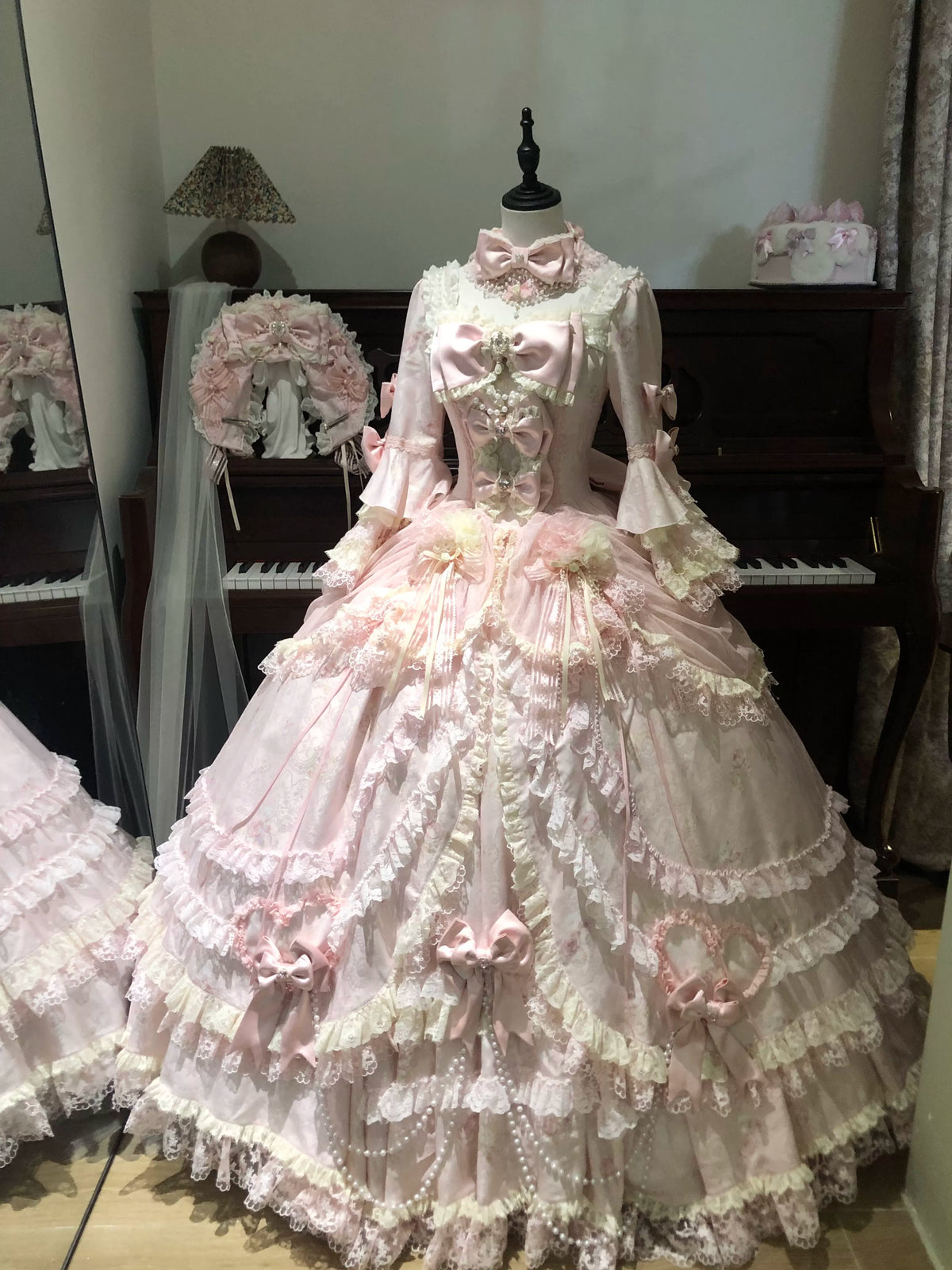 Full front view of pink Rococo Lolita gown with layered lace skirt on mannequin
